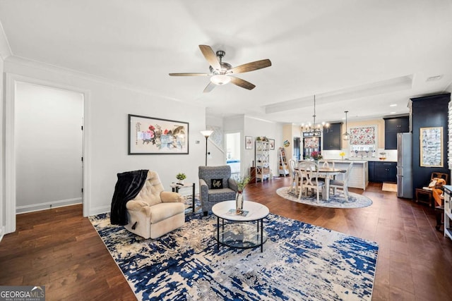 living room featuring baseboards, dark wood finished floors, and ceiling fan with notable chandelier