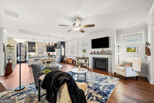 living area featuring visible vents, plenty of natural light, and dark wood-type flooring