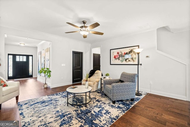 living area featuring baseboards, a ceiling fan, wood finished floors, and crown molding