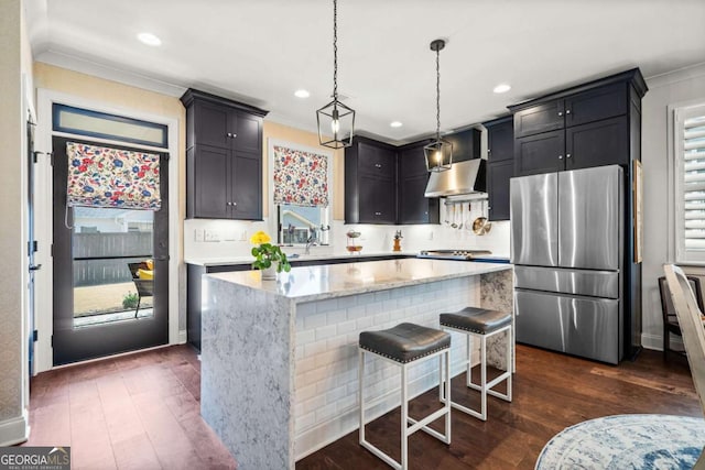 kitchen with a kitchen island, freestanding refrigerator, dark wood-type flooring, and exhaust hood