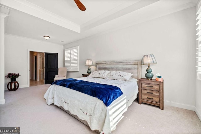 carpeted bedroom with a tray ceiling, crown molding, baseboards, and ceiling fan