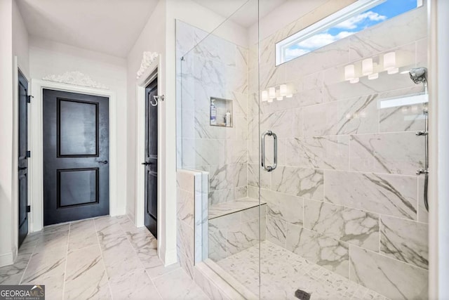 bathroom with marble finish floor and a shower stall