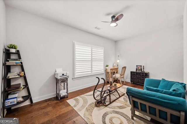 sitting room featuring visible vents, baseboards, dark wood-style flooring, and ceiling fan