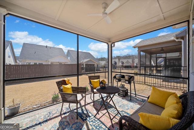 sunroom with a residential view and ceiling fan