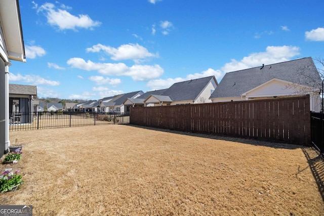 view of yard featuring a fenced backyard and a residential view