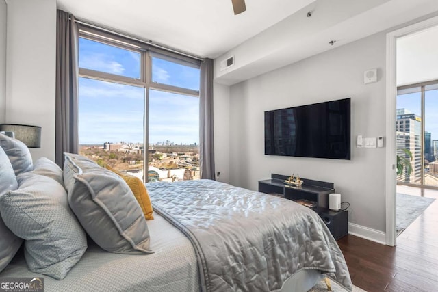 bedroom featuring visible vents, multiple windows, dark wood-type flooring, and baseboards