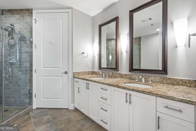 full bath with a sink, visible vents, double vanity, and a shower stall