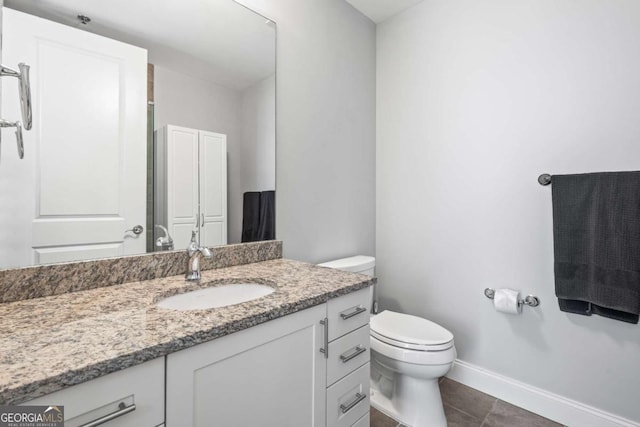 bathroom with tile patterned flooring, toilet, vanity, and baseboards