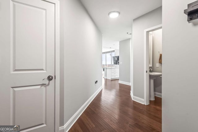 corridor featuring baseboards and wood finished floors