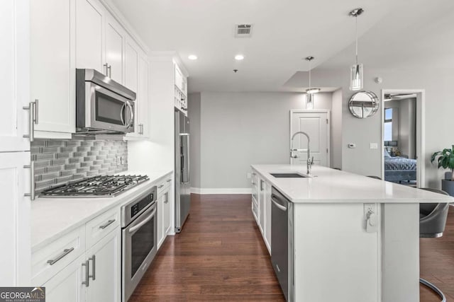 kitchen featuring visible vents, a sink, appliances with stainless steel finishes, white cabinetry, and backsplash