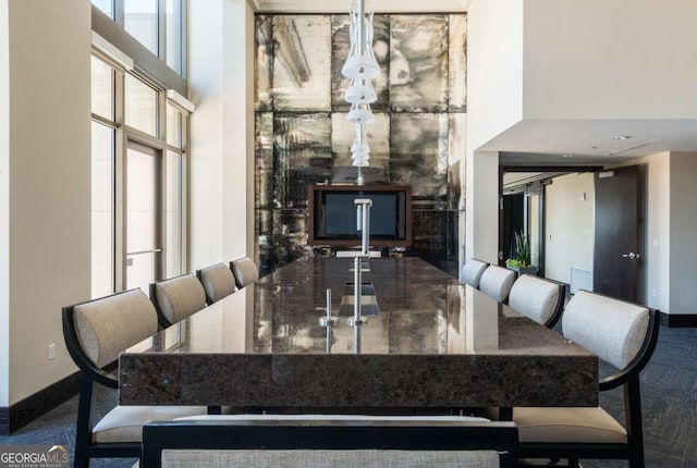 dining space featuring a high ceiling and baseboards