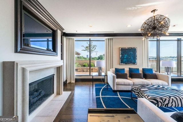 living area featuring a fireplace with flush hearth, recessed lighting, an inviting chandelier, and wood finished floors