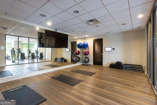 workout room with visible vents, baseboards, and wood finished floors