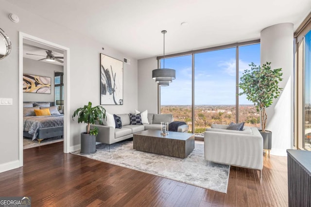 living room featuring a wall of windows, baseboards, wood-type flooring, and ceiling fan