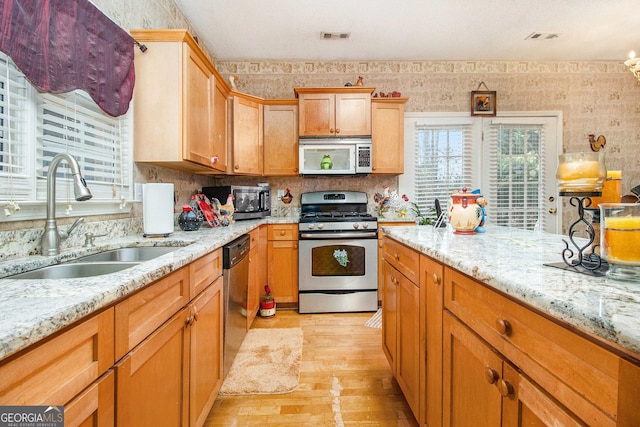 11 Tallulah Ct, Jonesboro, GA 30236 - kitchen featuring appliances with stainless steel finishes, light wood-type flooring, and light stone countertops