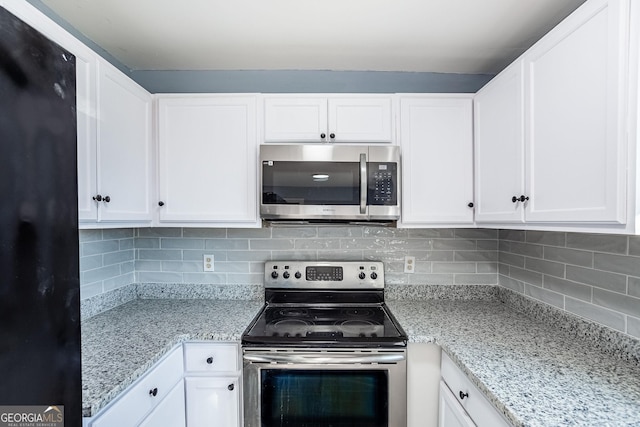 kitchen featuring light stone counters, decorative backsplash, white cabinets, and stainless steel appliances