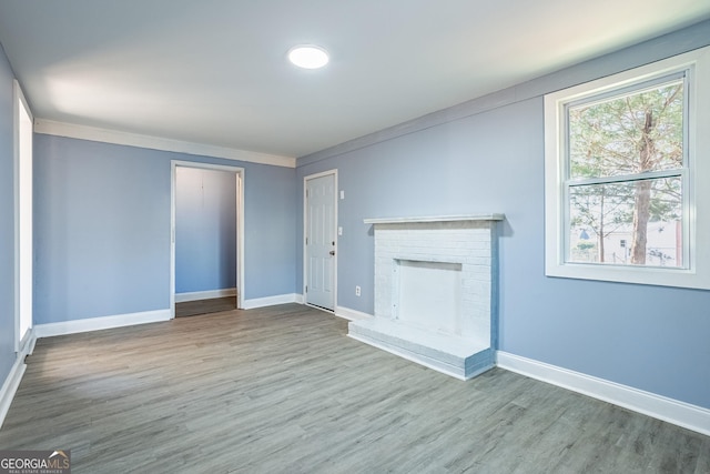 unfurnished living room with a fireplace, wood finished floors, and baseboards