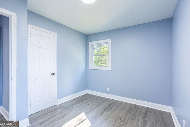 unfurnished room featuring wood finished floors and baseboards