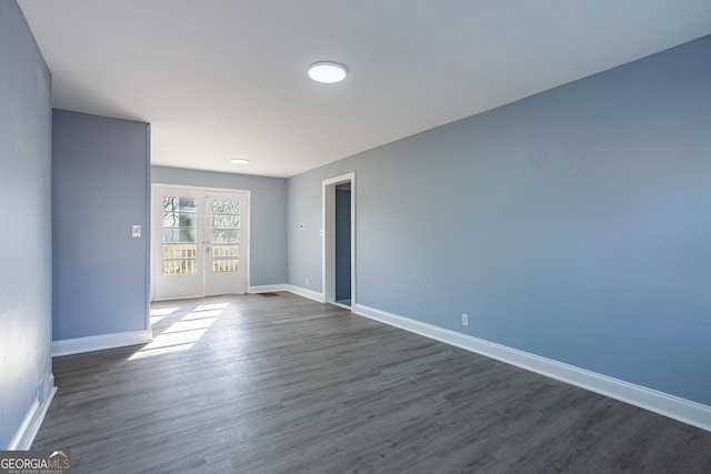 spare room with french doors, baseboards, and dark wood finished floors