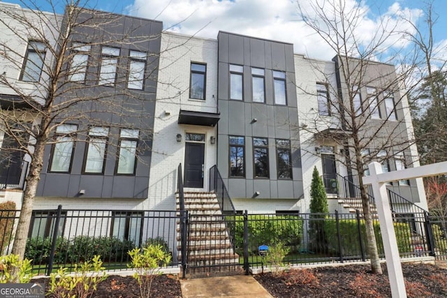 view of front of house with a fenced front yard and brick siding