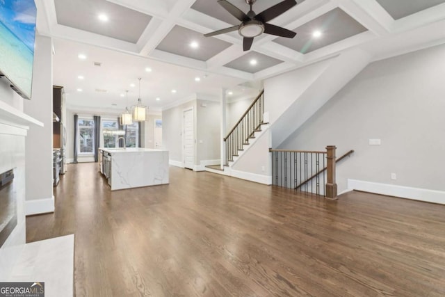 living area featuring baseboards, coffered ceiling, beam ceiling, a high end fireplace, and dark wood-type flooring