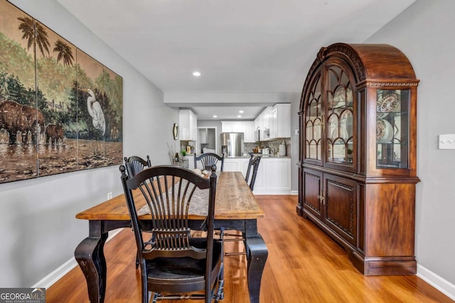 dining area featuring recessed lighting, baseboards, and light wood finished floors