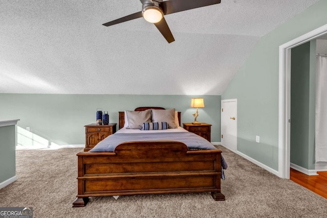 carpeted bedroom featuring ceiling fan, lofted ceiling, baseboards, and a textured ceiling