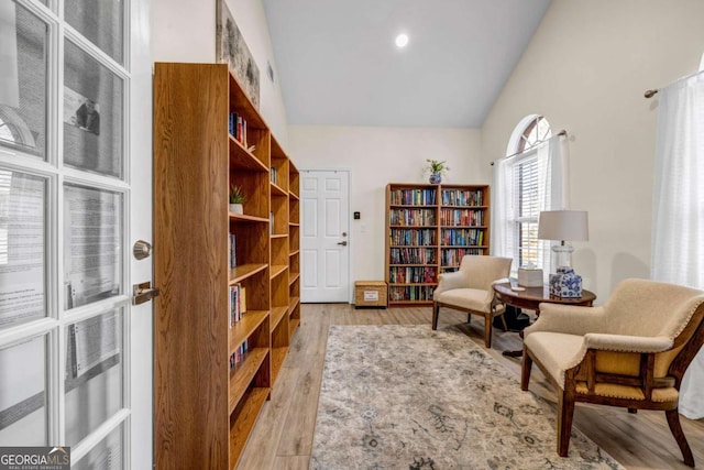 sitting room featuring light wood-style flooring and high vaulted ceiling