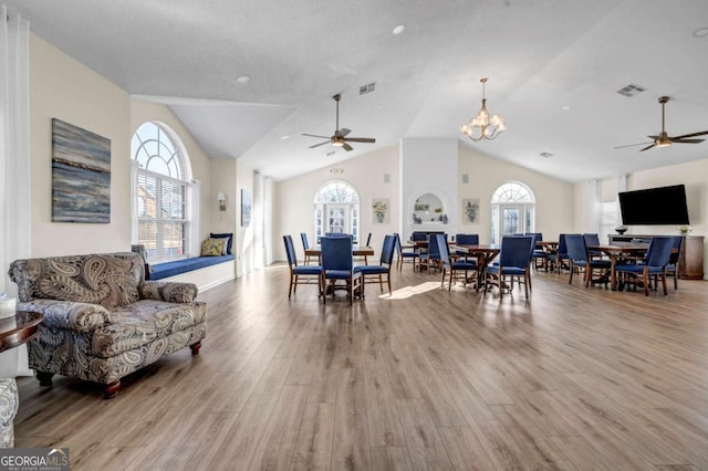 dining area featuring visible vents, wood finished floors, and ceiling fan with notable chandelier