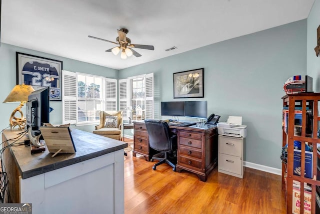 office with light wood-type flooring, visible vents, baseboards, and a ceiling fan