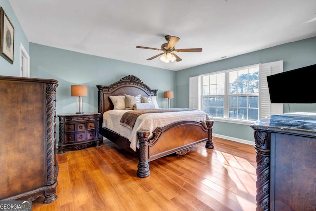 bedroom featuring ceiling fan, baseboards, and wood finished floors