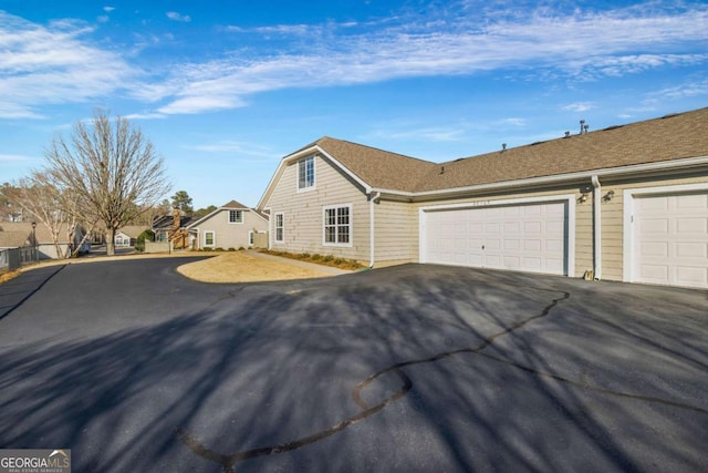 view of front facade with driveway and fence