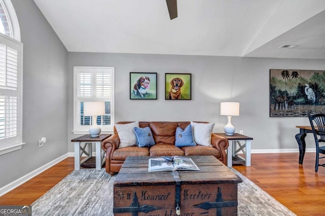 living room with vaulted ceiling, wood finished floors, baseboards, and ceiling fan