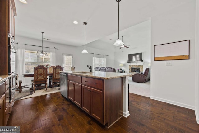 kitchen featuring dark wood-type flooring, a fireplace, stainless steel appliances, a ceiling fan, and a sink