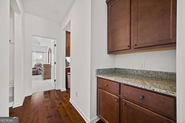 corridor featuring baseboards and dark wood-style flooring