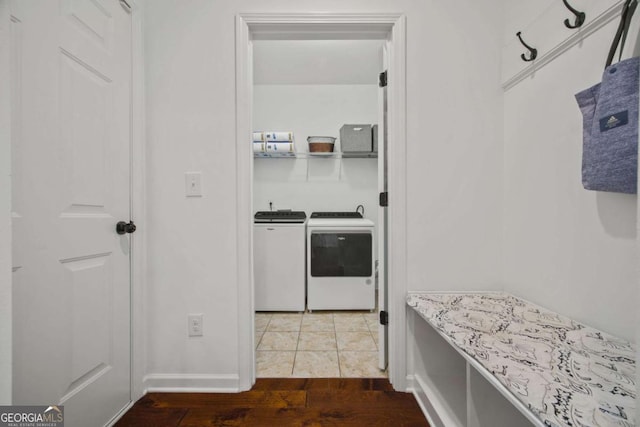 washroom with laundry area, wood finished floors, and washing machine and clothes dryer