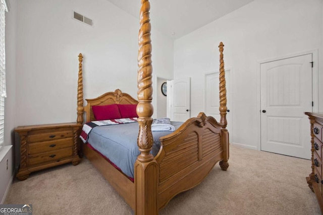 carpeted bedroom with lofted ceiling and visible vents