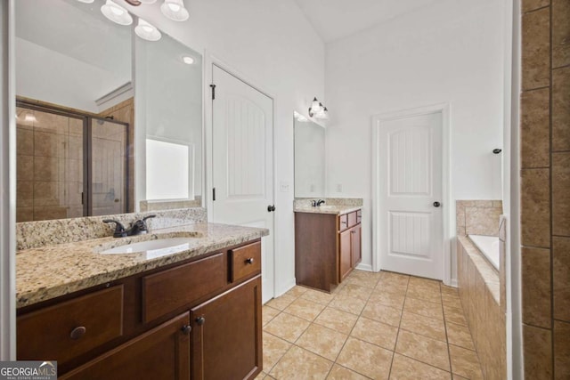 bathroom featuring a sink, two vanities, a stall shower, and tile patterned floors