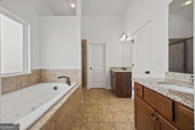 full bathroom featuring tile patterned flooring, two vanities, a stall shower, a tub with jets, and a sink