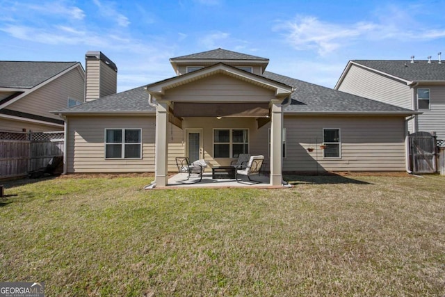 rear view of house with a patio, a fenced backyard, a lawn, and roof with shingles