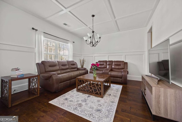 living area with visible vents, a chandelier, a decorative wall, coffered ceiling, and dark wood-style flooring