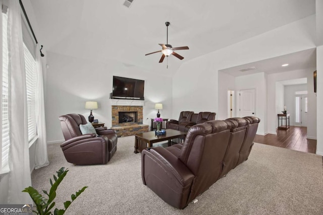 carpeted living area featuring visible vents, baseboards, a fireplace, lofted ceiling, and ceiling fan