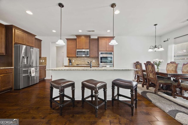 kitchen featuring tasteful backsplash, visible vents, stainless steel appliances, and dark wood-style flooring