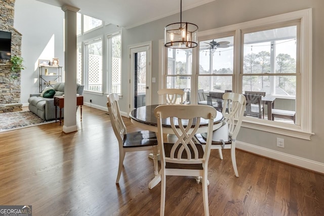 dining area featuring ceiling fan, decorative columns, baseboards, and wood finished floors