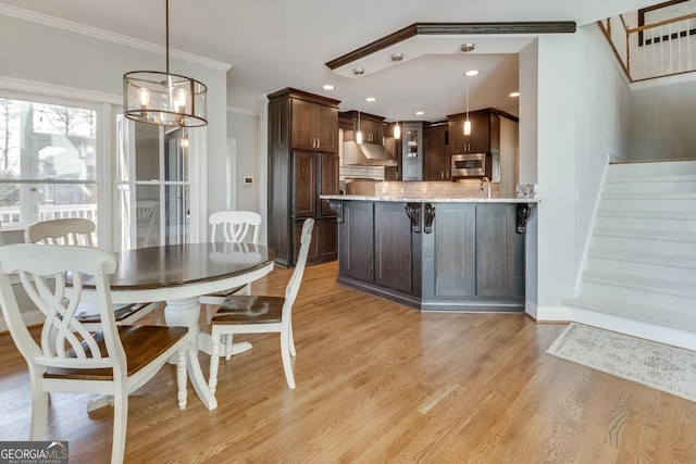 dining space with recessed lighting, crown molding, light wood finished floors, baseboards, and stairs