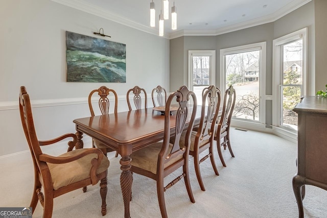 dining area featuring ornamental molding, plenty of natural light, and light carpet