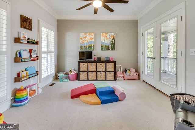 game room featuring carpet flooring, visible vents, crown molding, and a ceiling fan