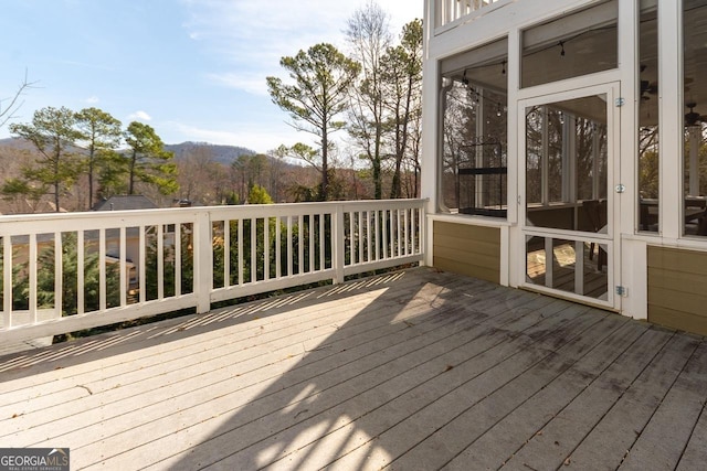 wooden deck featuring a mountain view and a sunroom