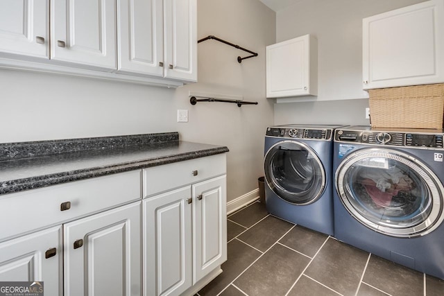 laundry area with cabinet space, independent washer and dryer, baseboards, and dark tile patterned flooring