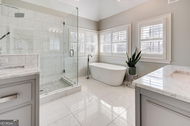 bathroom featuring visible vents, a soaking tub, a shower stall, and vanity